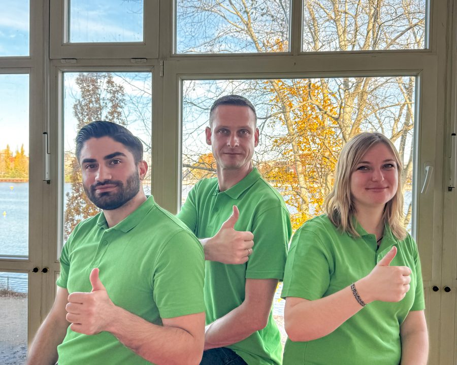 Drei Teammitglieder in grünen Poloshirts